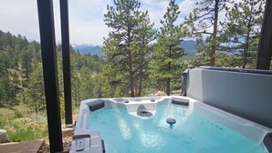 A hot tub with a mountain view, surrounded by trees. -  RIDGEVIEW RETREAT/ Huge views! Hot tub, fireplaces, A/C,  and location! (Estes Park)