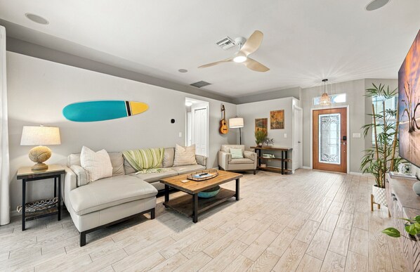 A modern living room with a sofa, coffee table, and a ceiling fan.