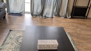 A dark wooden coffee table with a box labeled "HAPPINESS" in the center.