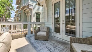 A covered porch with wicker furniture and a sliding glass door.
