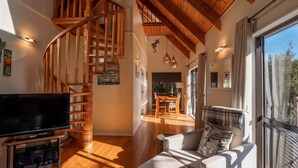 A spacious living area with a wooden staircase, a flat-screen TV, and a cozy seating area with a view of the outdoors. - 4 Wheel Drive included. 5-minute walk from Ferry to car.
Hot on arrival Spa Pool (Onetangi)