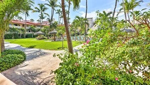 A resort with a pool area, palm trees, and a well-maintained lawn. - Marina Sol Los Cabos Haven - Walk to Medano Beach! (Cabo San Lucas)