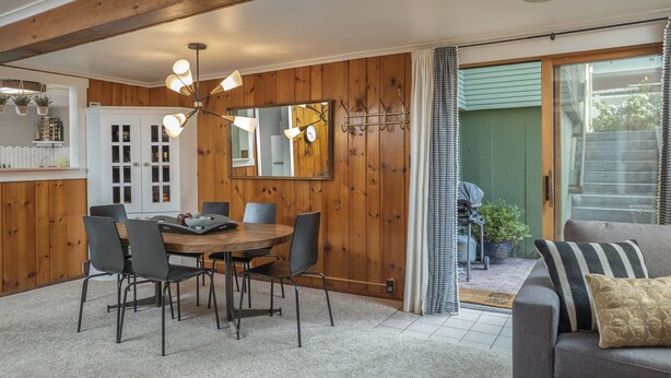 A dining area with a wooden table and chairs, a chandelier, and a view of the outside. - Clean, comfortable, spacious Fort Grounds apartment: great location!  (Coeur d'Alene)