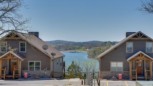 Un bâtiment de style cabane avec un quai s’avançant dans un lac, le tout entouré de collines.