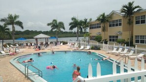 A swimming pool area with lounge chairs and a pavilion. - Best deal on the beach/sleeps 6/All New/Gulf views!/55 inch TV (Indian Shores)