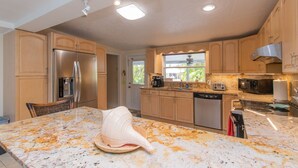 A modern kitchen with granite countertops, stainless steel appliances, and wooden cabinets. - Waterfront & Privacy, Heated Pool  HotTub & waterfall, 60' Dock TikiHut, pets ok (Marathon)