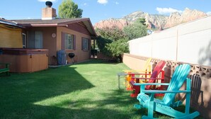 A backyard with a hot tub, grill, and colorful Adirondack chairs. - Great Location Best Value Beautiful House and Guest House with Views (Sedona)
