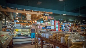 A bakery interior with a display case, shelves of baked goods, and a person standing near the counter. - 🌷 Das Tulip, the perfect place to stay in Helen. Center of town, Ground floor🏰 (Helen)