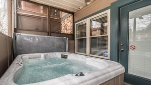 A hot tub in a room with a door, windows, and a stone wall. - 🌷 Das Tulip, the perfect place to stay in Helen. Center of town, Ground floor🏰 (Helen)