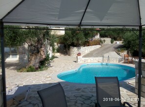 Relax by the pool surrounded by a patio and lounge chairs.