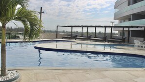 A swimming pool with lounge chairs and a palm tree.