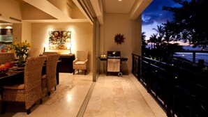 A dining area with wicker chairs, a table with fruit, and a painting. - Molino de Agua Next to Los Muertos Beach! 3BD Condo for rent in Los Muertos Beac (Puerto Vallarta)