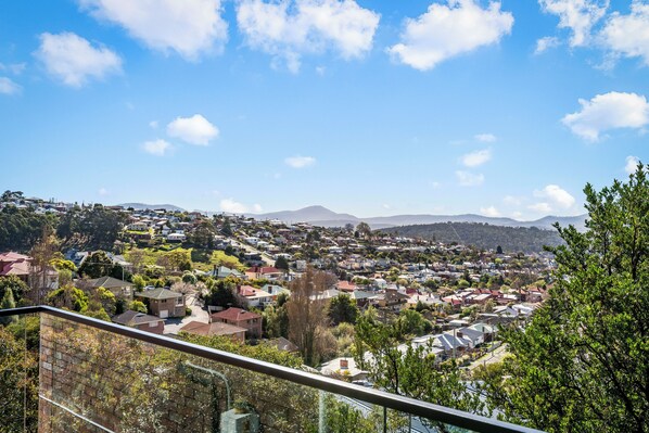 A residential area with houses, trees, and a mountain in the background.