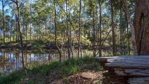 A natural landscape with a body of water, trees, and a stone structure.