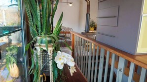 A modern kitchen with a built-in stove, wooden railing, and potted plants. - TreeTops House near Bright with Mtn & pool views (Tawonga South)