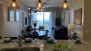 Een moderne keuken met granieten aanrecht, een roestvrijstalen spoelbak en hangende lampen.