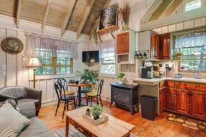 A cozy room with a fireplace, wooden furniture, and a dining area.