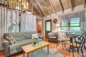 A cozy living room with a sofa, a coffee table, and a dining area with chairs and a table. - Back on Market! Creekside Studio Near Table Rock (Table Rock)