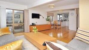 Una sala de estar moderna con un sofá, una mesa de centro y un comedor con sillas y una mesa.