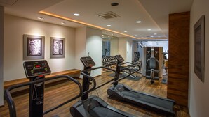 Un gimnasio con cintas de correr, elípticas y pesas.