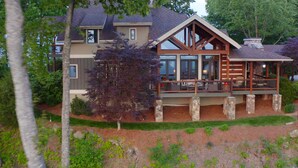 A large, multi-story house with a prominent porch and stone pillars. - Gated Luxury Lodge - Hot Tub, Mountain Views, Stunning Gardens, Secluded (Franklin)