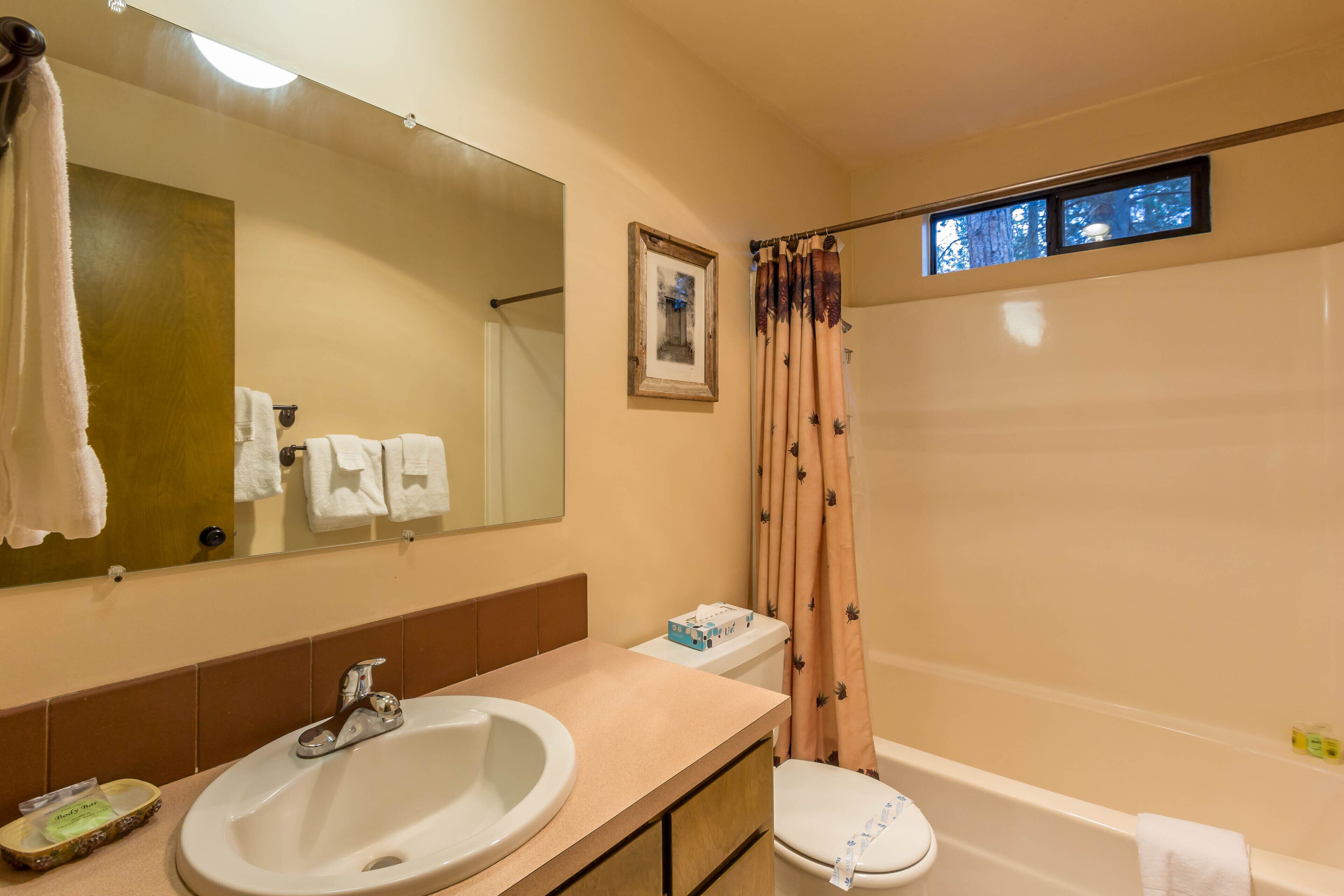 A bathroom with a sink, toilet, and bathtub.