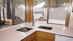 A kitchen with two sinks, wooden cabinets, and a dishwasher. - Cozy Pet Friendly Cabin, Wood Fireplace, Hot Tub, SHARC passes, close to Village (Sunriver)