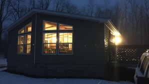 A small, single-story building with multiple windows, a garage, and a snow-covered ground. - Best of both worlds! Amazing views plus an easy walk into town! (New Paltz)