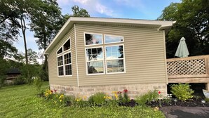 A small, single-story house with a sloped roof and a large window on the front. - Best of both worlds! Amazing views plus an easy walk into town! (New Paltz)