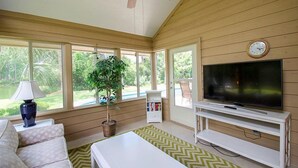Un salon équipé d’un téléviseur, d’un canapé, d’une table basse et d’un ventilateur de plafond.