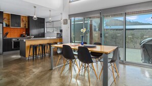 A modern kitchen with dark cabinets, an orange backsplash, and a wooden island.