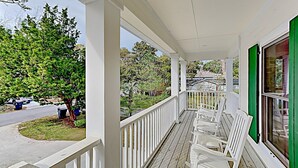 A covered porch with white railings and wooden flooring, featuring several white chairs and a green window. - Deetjen Beach House - Near Beach & Bike Trail. North Litchfield Favorite! (Pawleys Island)
