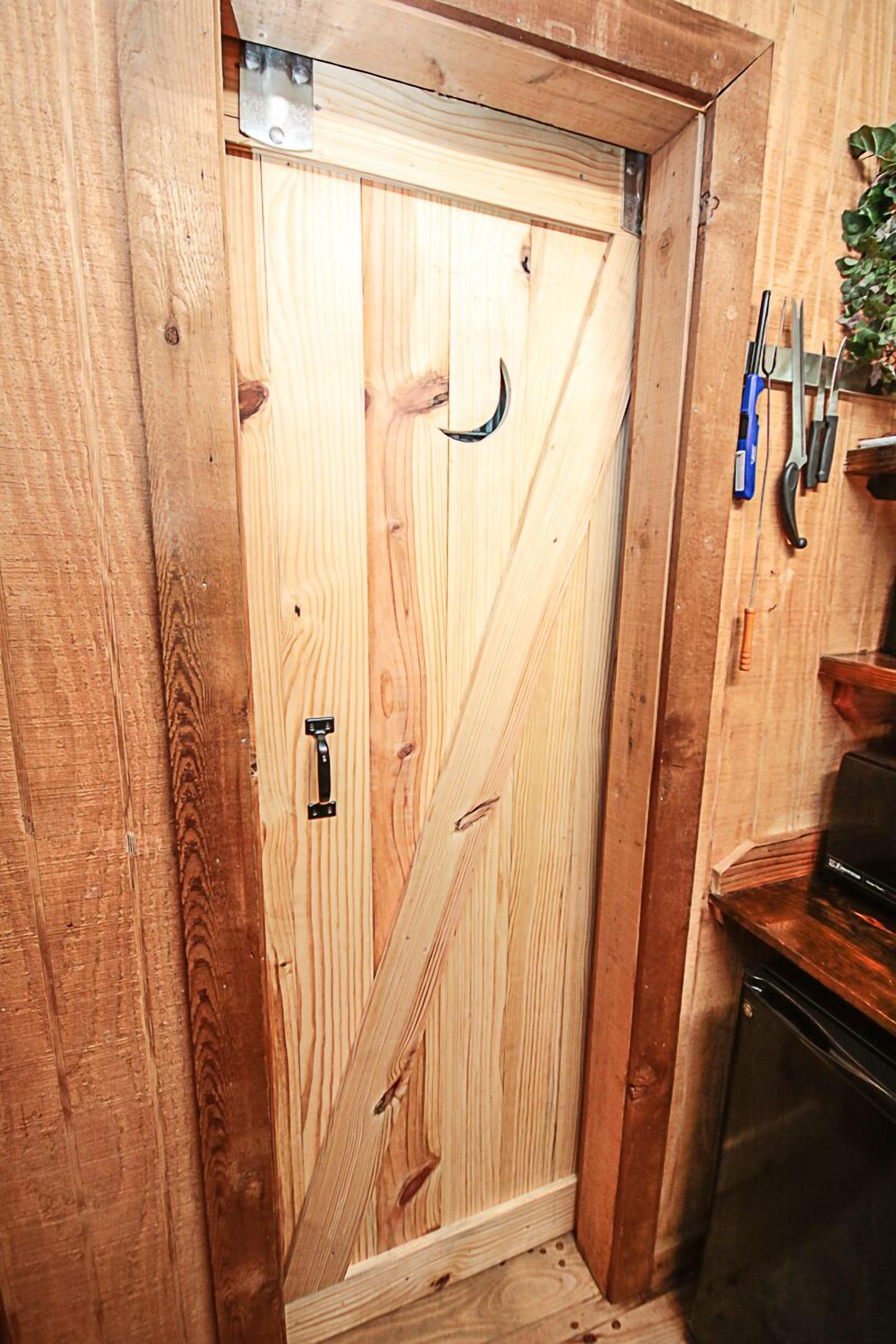 A wooden door with a black handle and a metal latch.