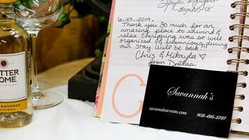 Un cuaderno con una nota escrita a mano, una botella de vino y una tarjeta de presentación.