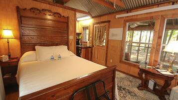 Une pièce en bois avec un lit, une table de chevet, un bureau et une fenêtre.