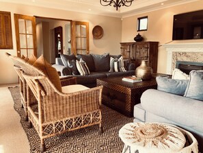 Una sala de estar con sofá, sillón, mesa de centro y chimenea.