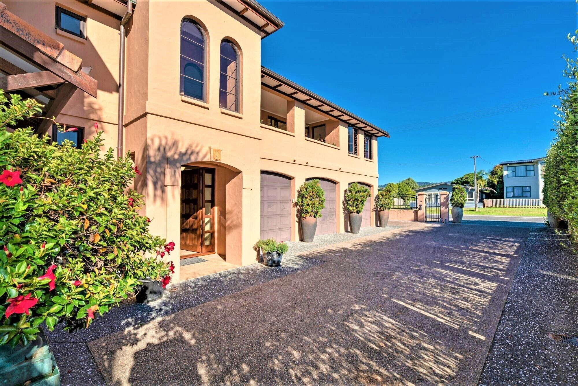 A two-story building with a driveway leading to a gated entrance.