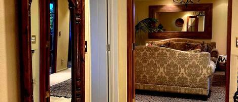 Un dormitorio con una cama grande, un banco de madera y un espejo en la pared.