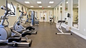 A gym with various cardio machines, a mirrored wall, and a clean, tiled floor. - Family Friendly 2BR Condo at Oakwater Resort – 1.5 Miles to Disney (Kissimmee)