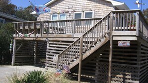 Ein Holzhaus mit Balkon und einer Treppe, die zu einem zweiten Stock führt.