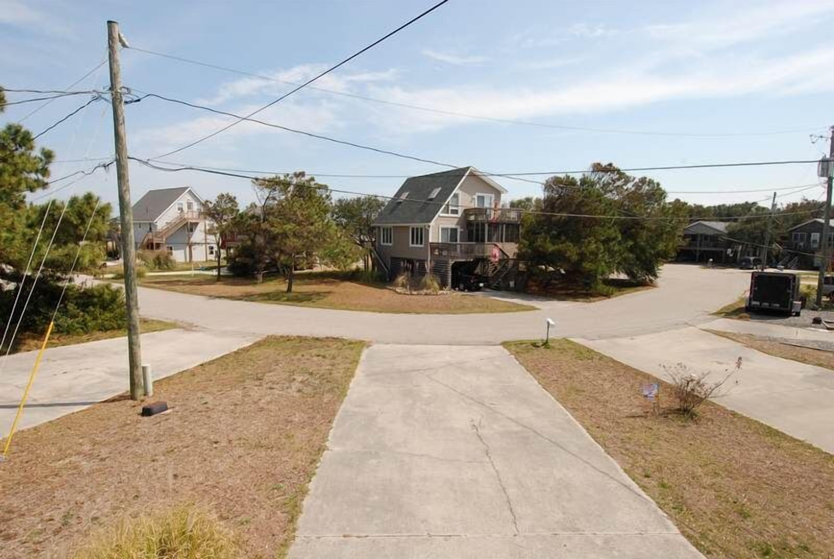 A residential area with houses, a sidewalk, and utility poles.