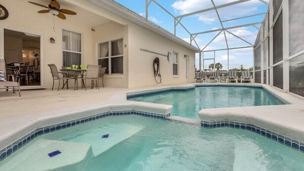 A pool area with a ceiling fan, outdoor seating, and a covered patio. - 4 bedrooms home with private pool- 15 min from Disney (Davenport)
