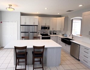 Prepare meals with ease in this kitchen featuring a central island, stainless steel appliances, and ample workspace.