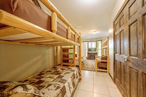 A room with bunk beds, a television, and a wooden wardrobe. - Hot Tub & Mtn Views: Beautiful Bryson City Home (Bryson City)