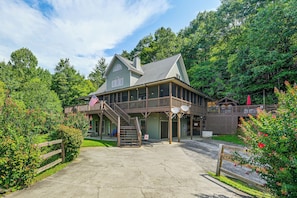 A two-story building with a porch, a flag, and satellite dishes. - Hot Tub & Mtn Views: Beautiful Bryson City Home (Bryson City)