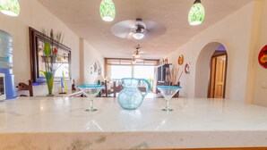 A kitchen with a marble countertop, a ceiling fan, and a large window. - Playa Bonita Casa de Risa located on Los Muerto Beach  2BD Condo for rent in Los (Puerto Vallarta)