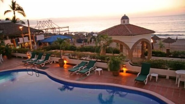 A pool area with lounge chairs and a view of the ocean at sunset. - Playa Bonita Casa de Risa located on Los Muerto Beach  2BD Condo for rent in Los (Puerto Vallarta)