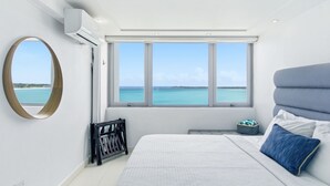 Un dormitorio con una cama grande, vista al mar y un tragaluz.