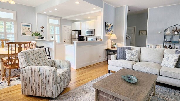 Una sala moderna con sofá, sillón y mesa de centro.