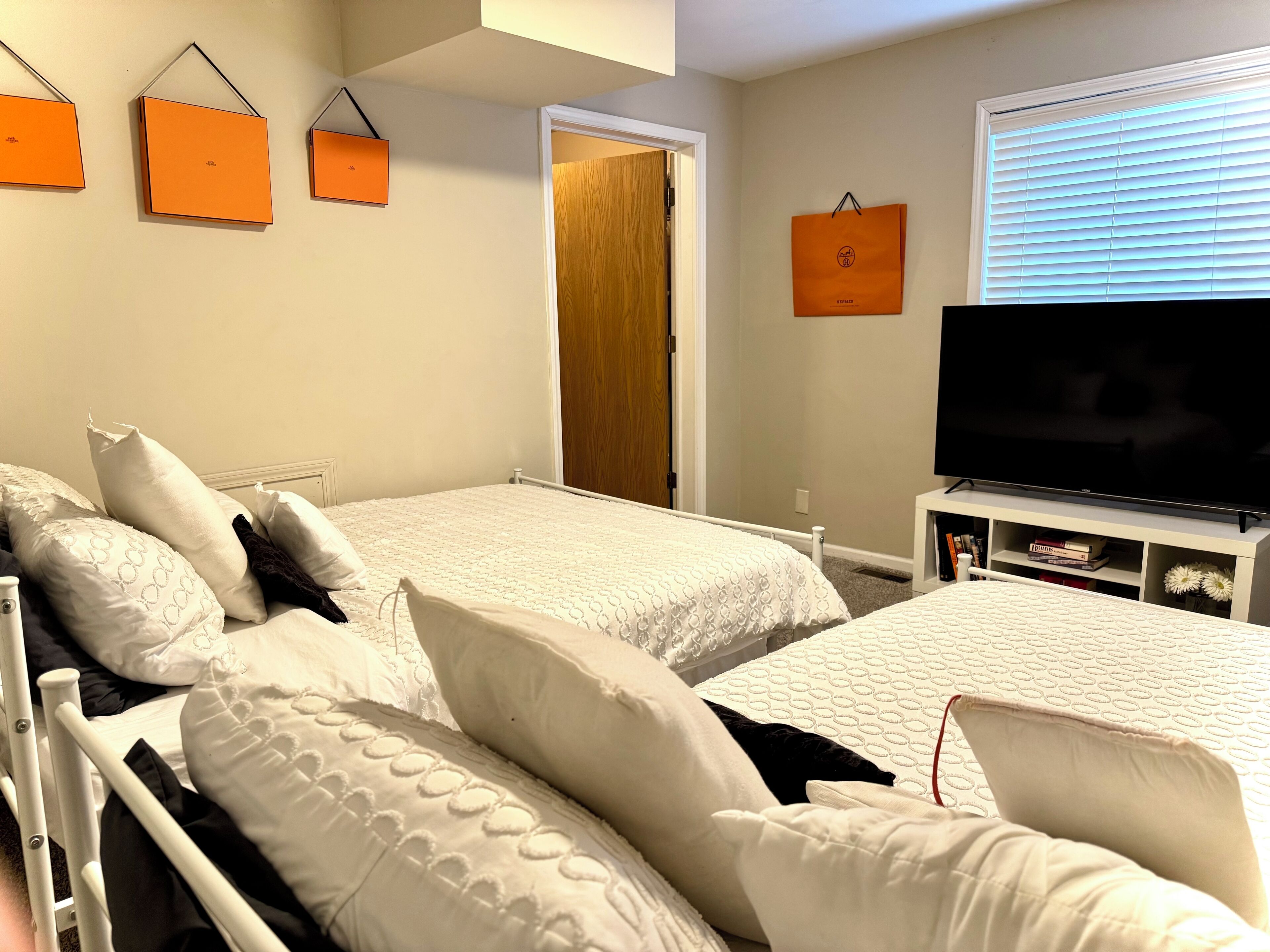 Ett hotellrum med två sängar, en TV och ett fönster med persienner.
